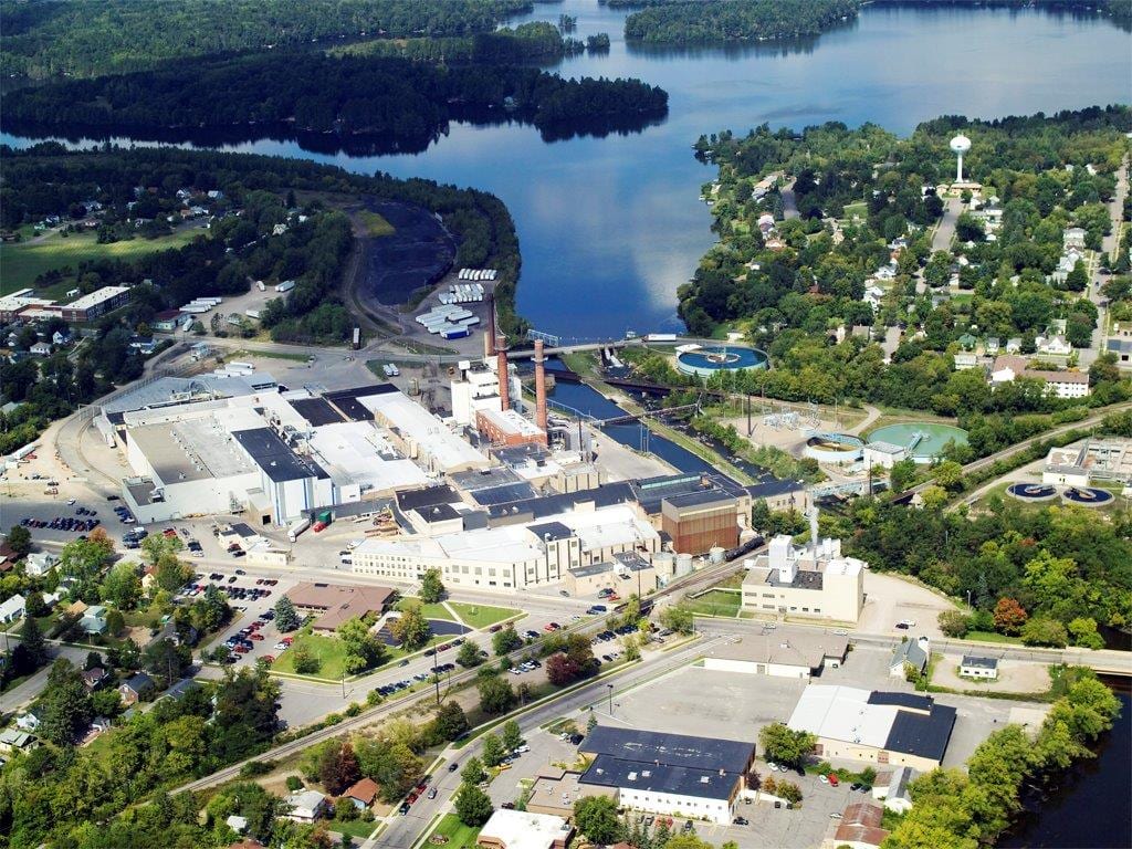 Aerial image showcasing industrial buildings alongside a river and lush greenery in Oneida County