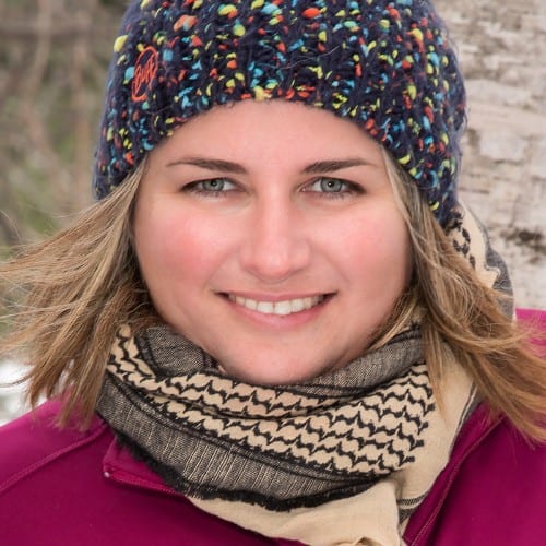 Woman in cozy winter attire smiling warmly outdoors in Oneida County