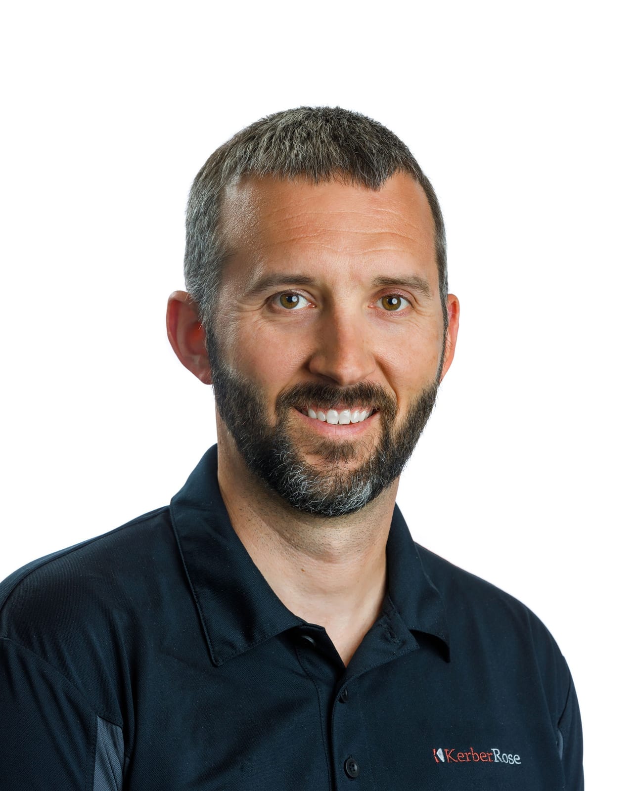 Portrait of a person with a short beard, smiling, wearing a dark shirt against a white background