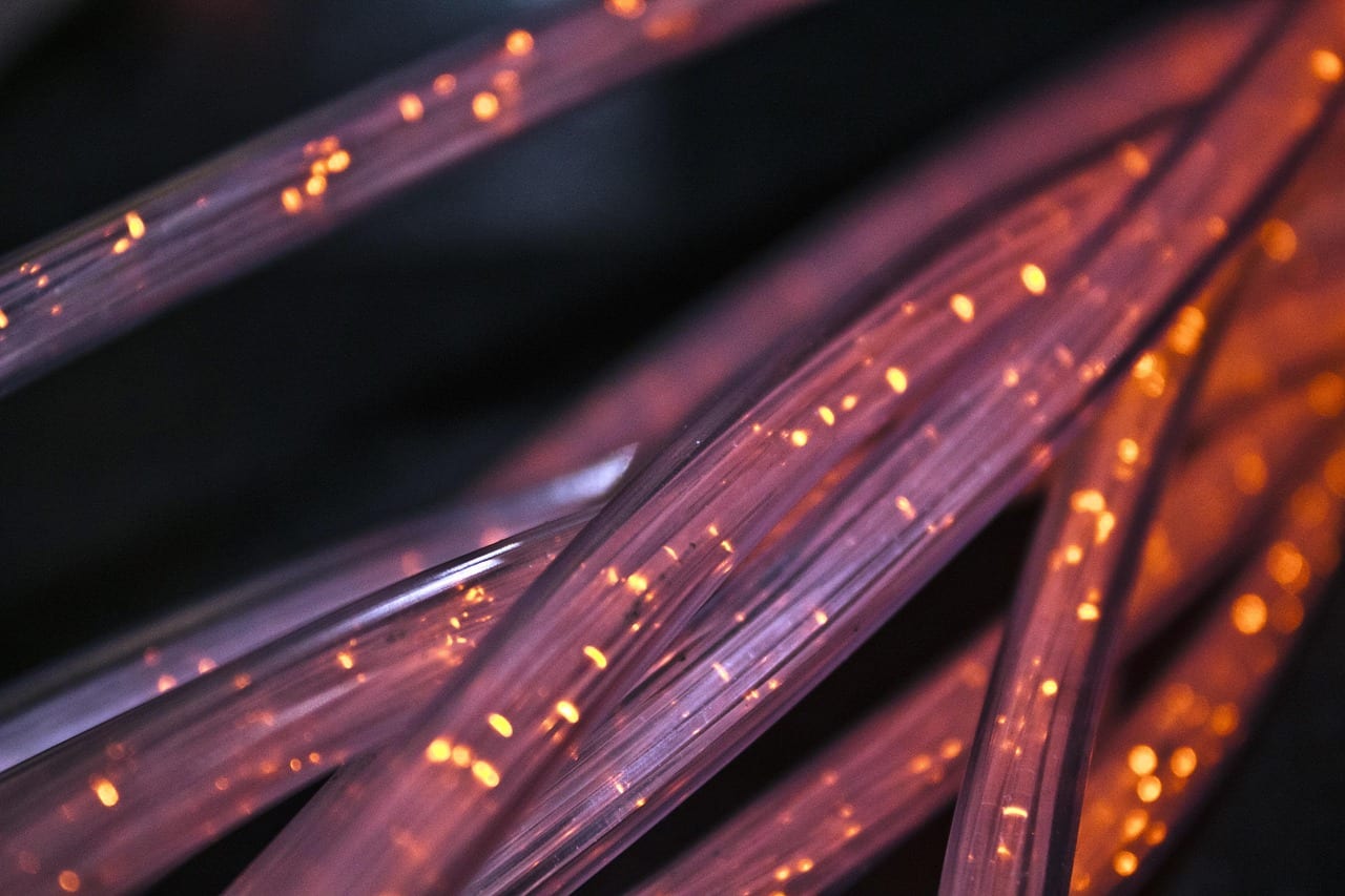 Detailed view of glowing fiber optic cables representing high-speed internet technology and communication infrastructure.