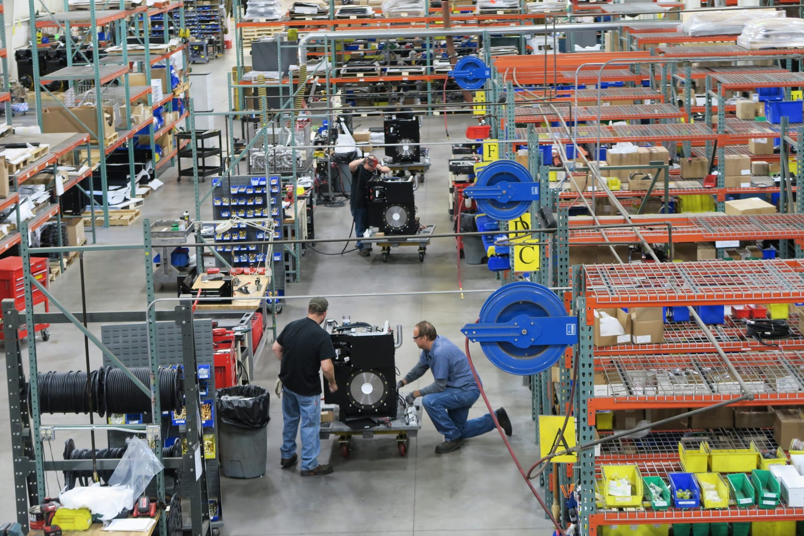 Aerial view of a bustling manufacturing facility with workers assembling machinery